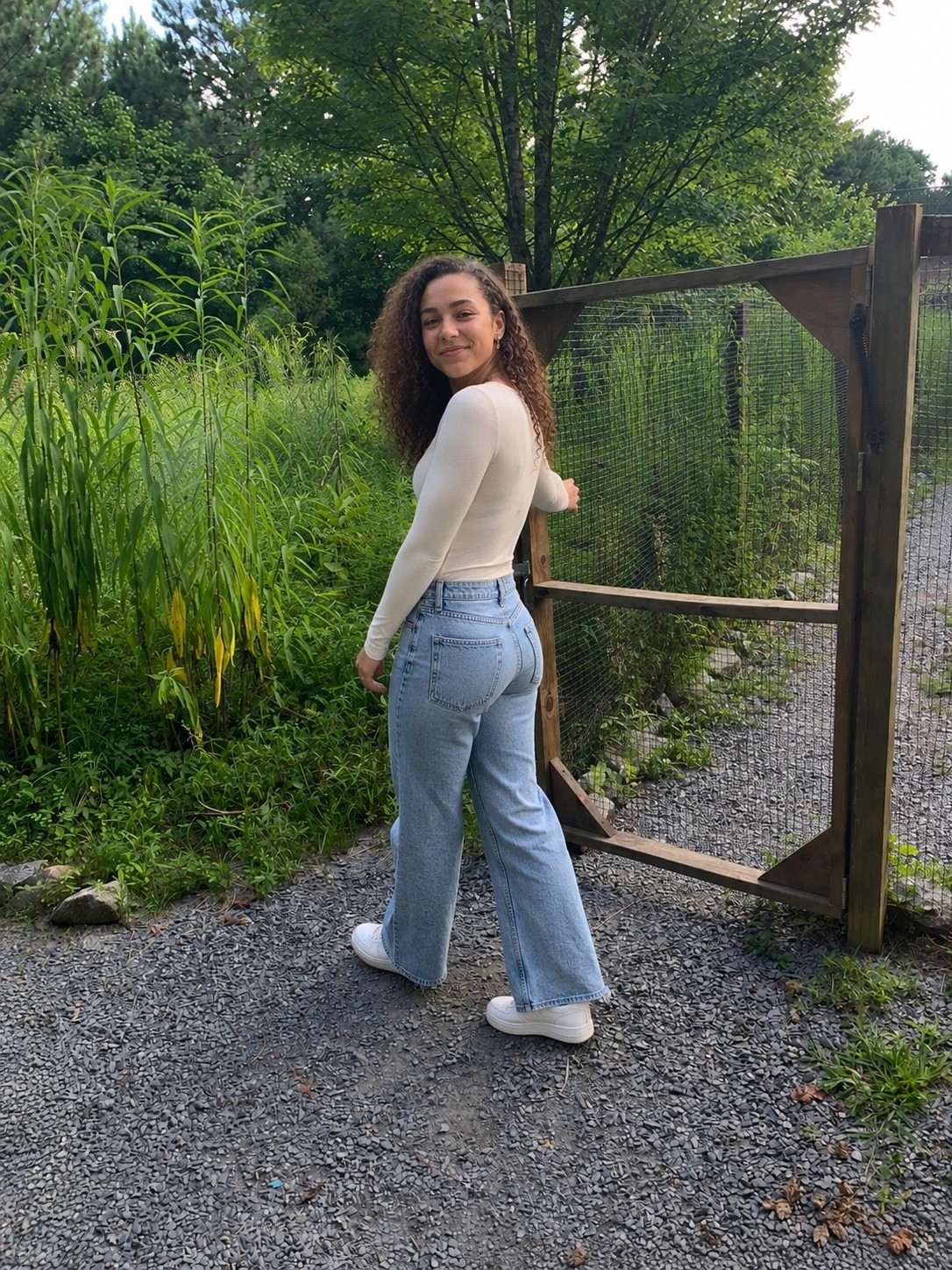 Research participant beside a gated trail entrance and tall vegetation